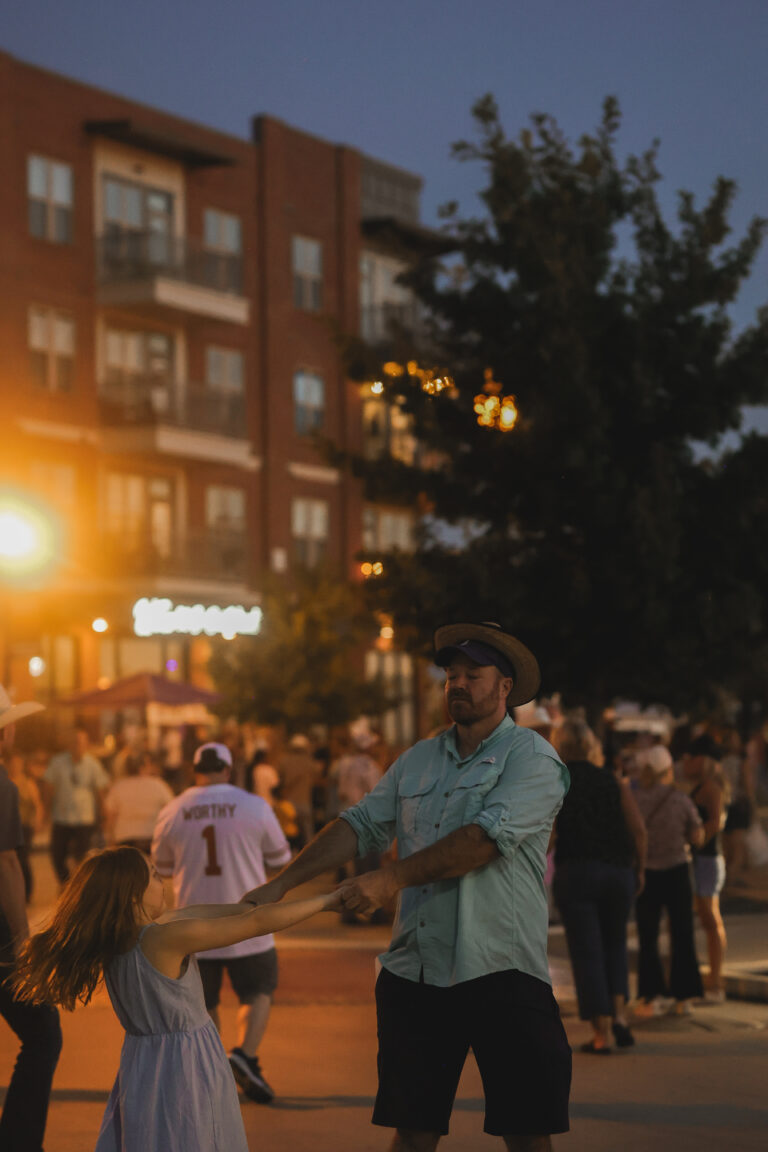 A father and daughter dancing in the street