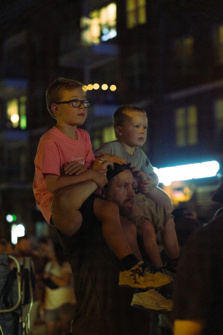 A man carrying two kids in his shoulders