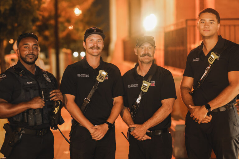 A police officer stands alongside three firefighters in the photo