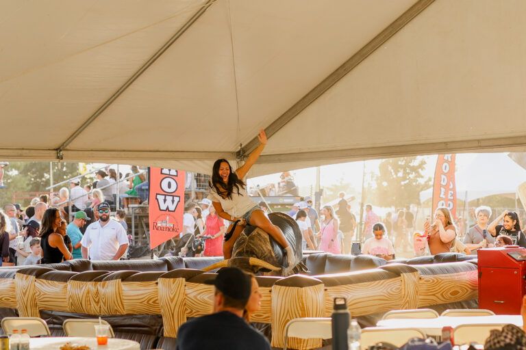 A woman is riding a mechanical bull